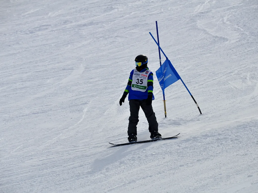 Snowboarder mit Startnummer 35 neben einem blauen Tor.